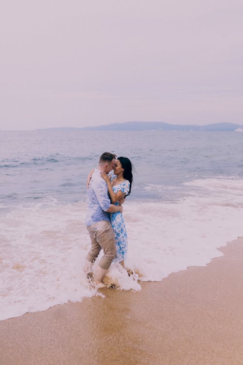 A couple embracing in the ocean during their engagement session