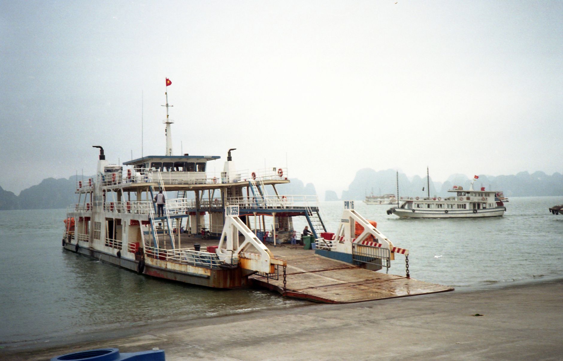 A ferry and traditional boats moored at Ha Long Bay, Vietnam.