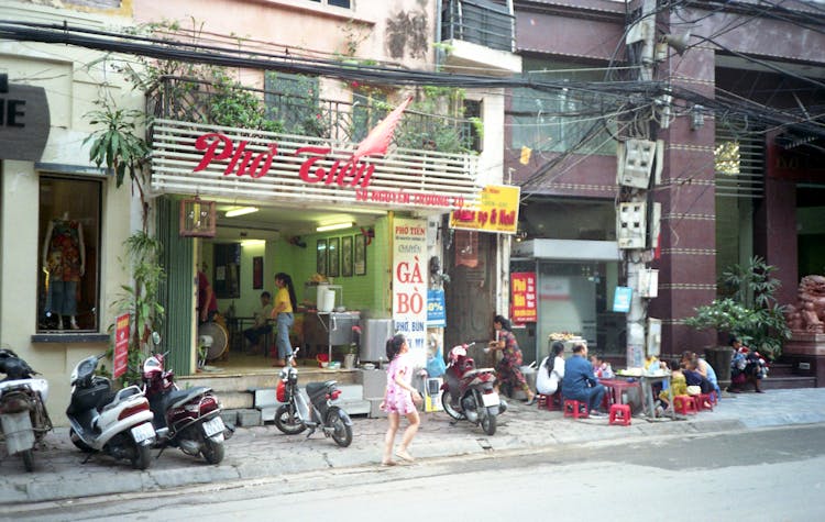 People Eating In Front Of A Restaurant 