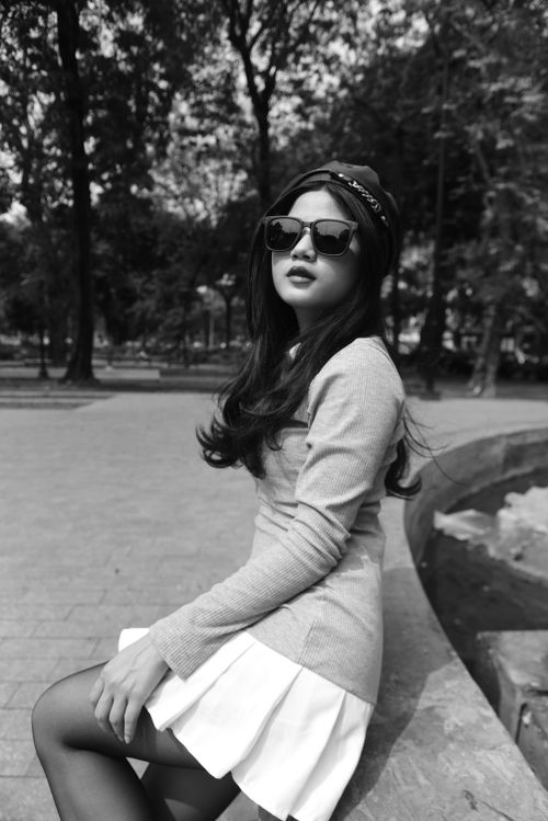 Free Elegant portrait of a stylish woman with sunglasses in a park setting. Stock Photo