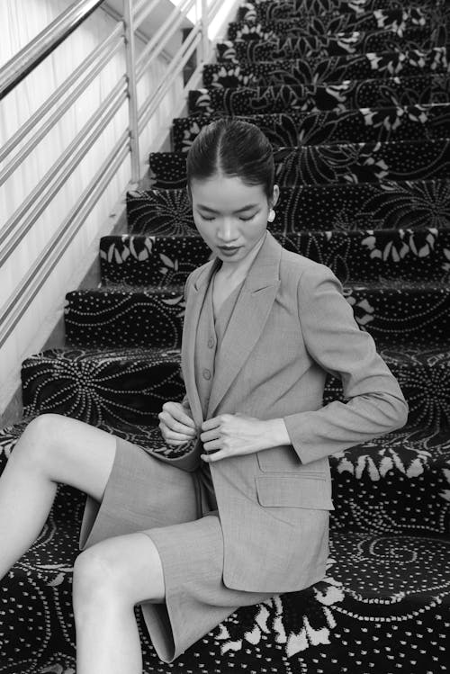 A woman in a suit sitting on some stairs