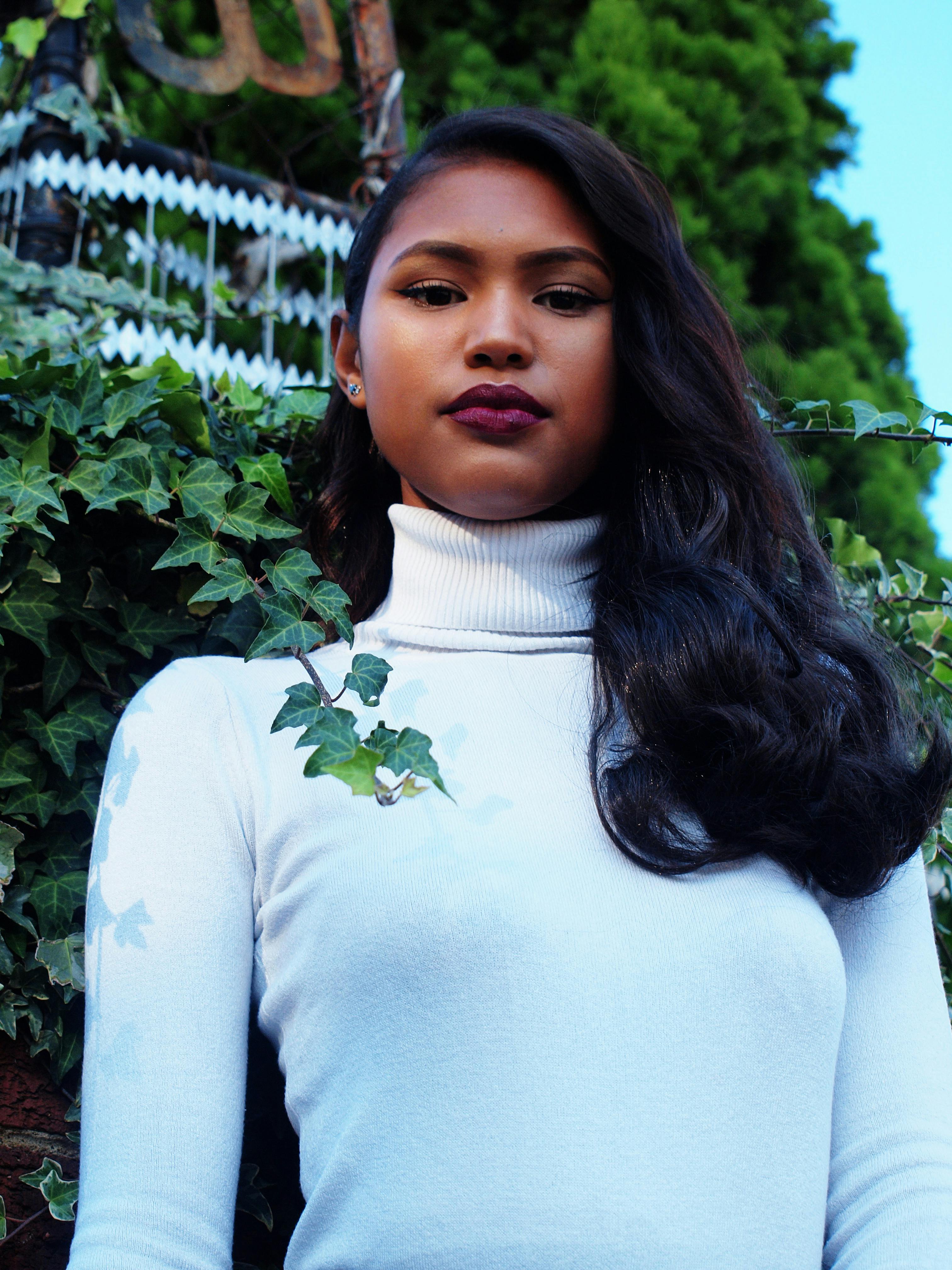 一位时尚女性在户外摆出优雅姿态，展现时尚与美丽