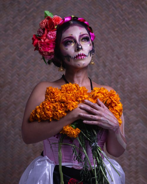 A woman in a skeleton costume holding flowers