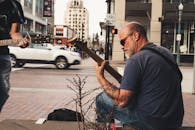 城市人行道上，街头音乐家弹着吉他，捕捉着充满活力的城市生活