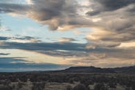 日落时分，沙漠景观与戏剧性的云层交相辉映，景色迷人