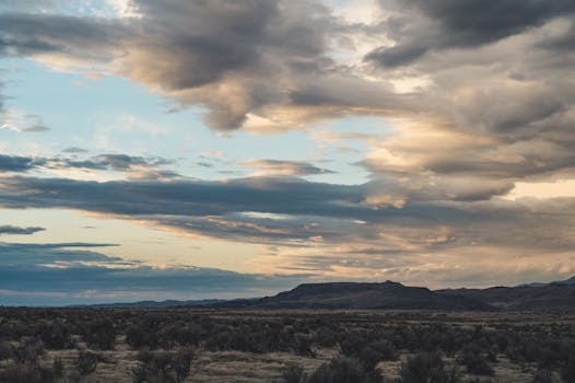 日落时分，沙漠景观与戏剧性的云层交相辉映，景色迷人