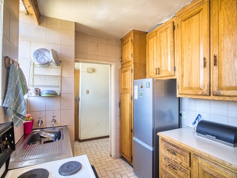 Warm and inviting kitchen with wooden cabinets, stainless steel appliances, and tiled walls.