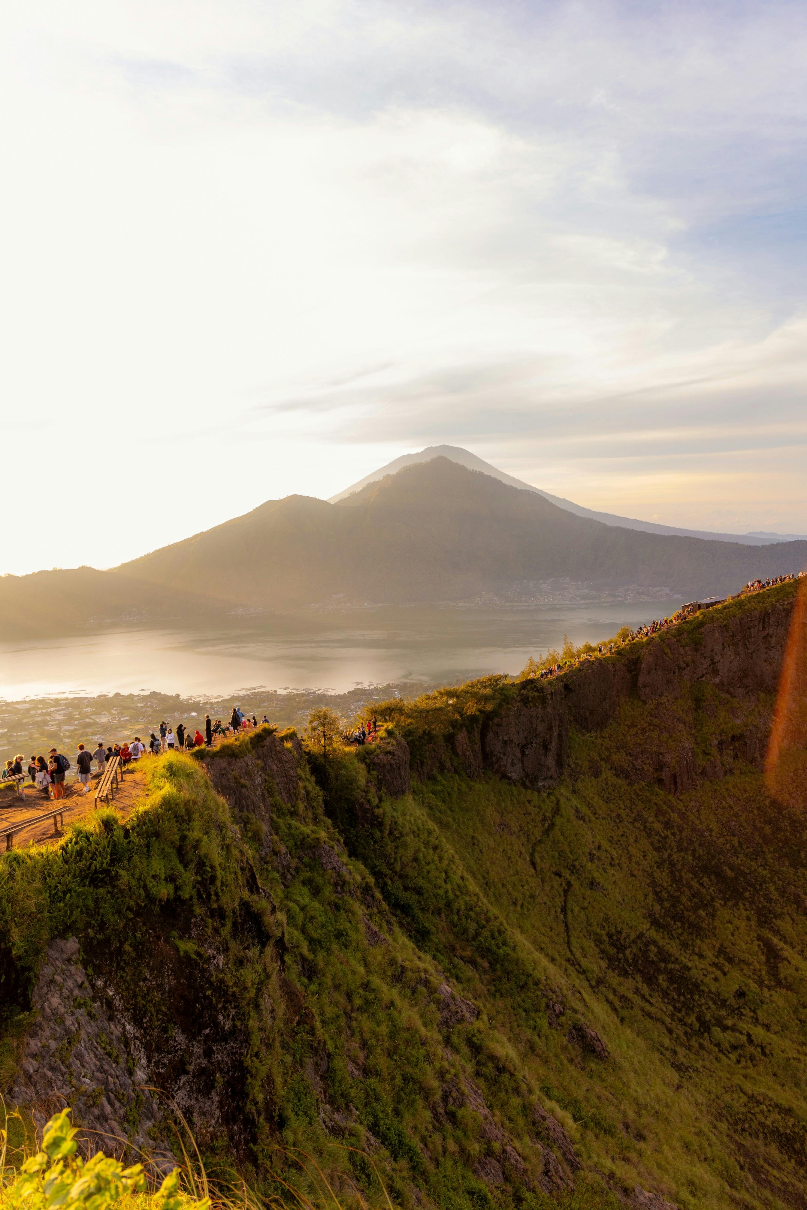 Sunrise over Mount Batur summit with Lake Batur and Mount Agung in the distance during a Bali volcano hike