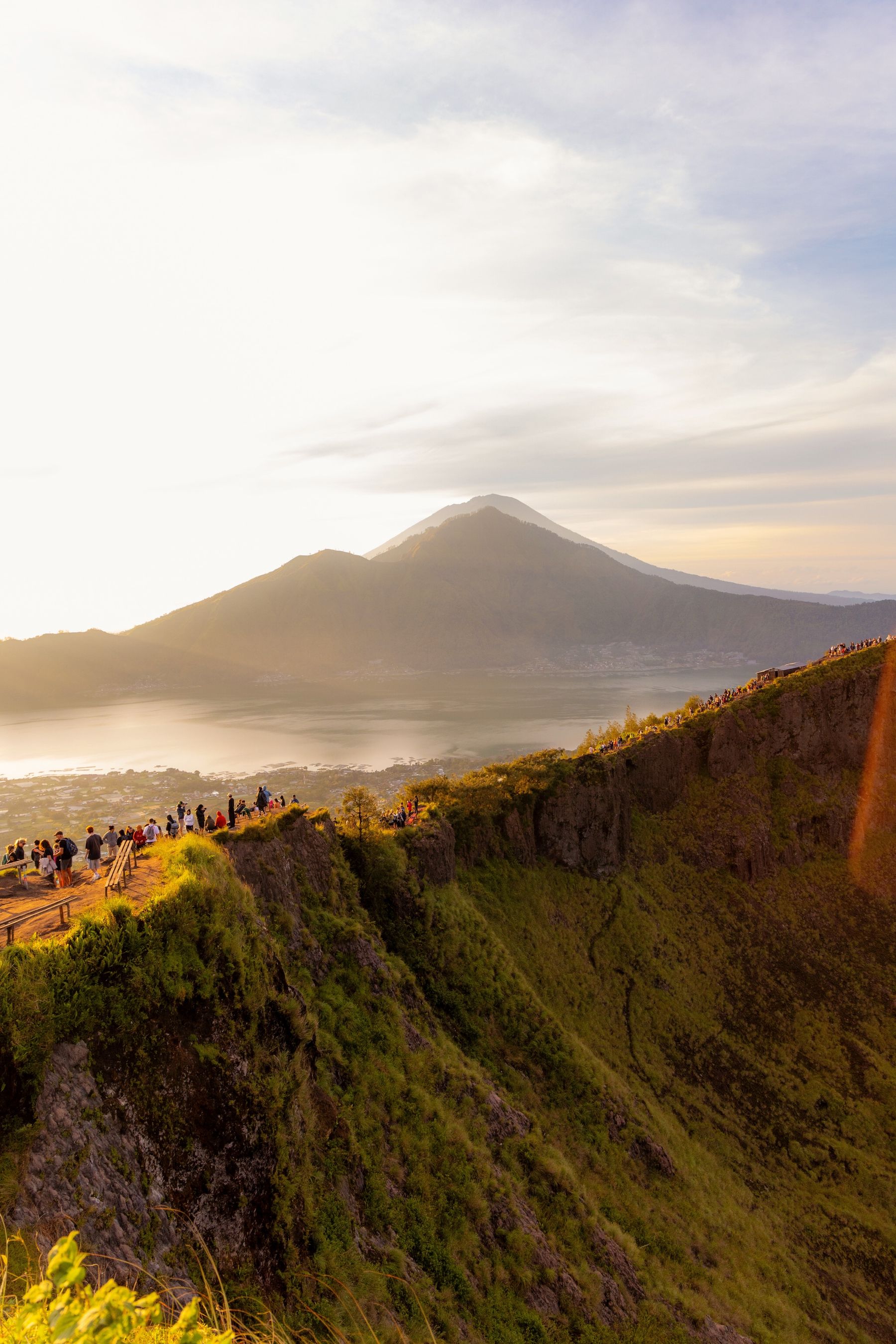 Travelers watching sunrise across Mount Batur's volcanic caldera in Bali