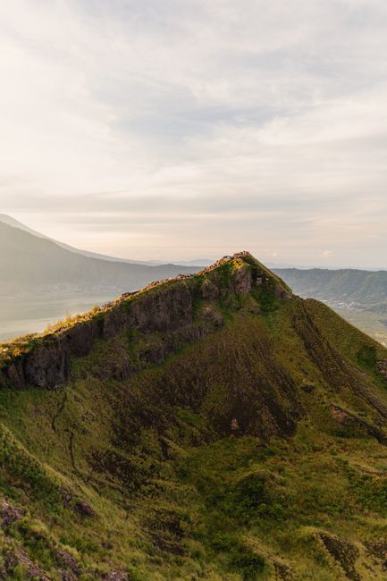 Lush green mountain range at sunrise offering a breathtaking view of nature's beauty in a serene countryside setting.