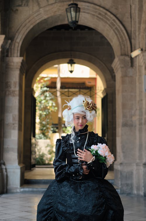 A woman in a black and white dress holding a bouquet