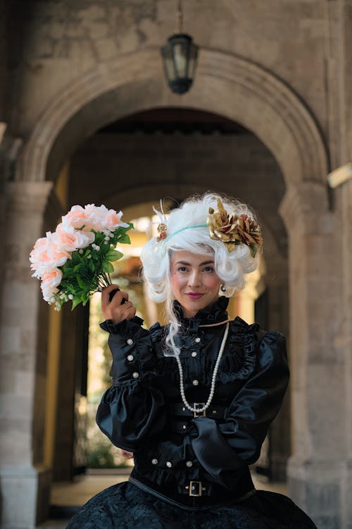 A woman in a black dress holding flowers