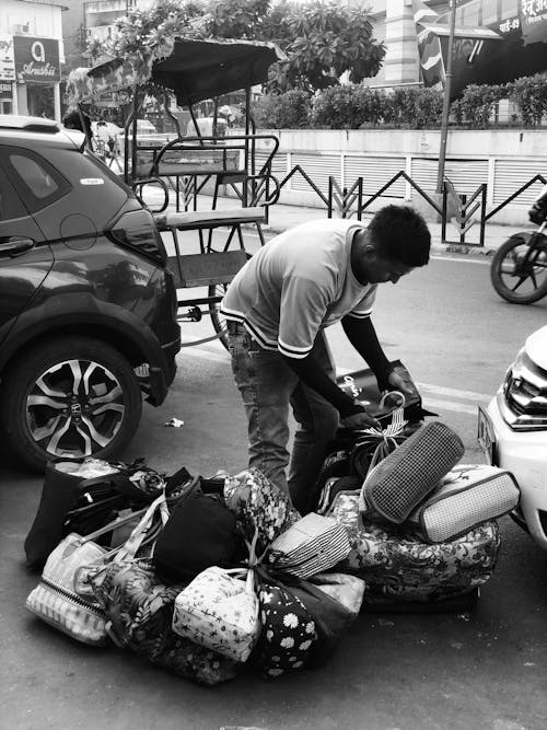 A man is loading bags onto a car