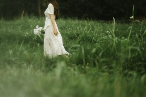 Free A peaceful moment captured as a woman walks through a green field in Lạng Sơn, Vietnam. Stock Photo