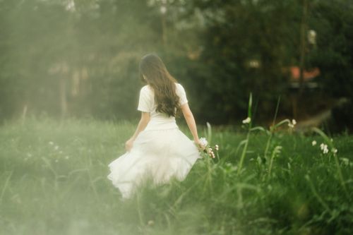 Free Woman walking in a serene meadow in Lạng Sơn, Vietnam. Fashion photography with a soft, dreamy mood. Stock Photo
