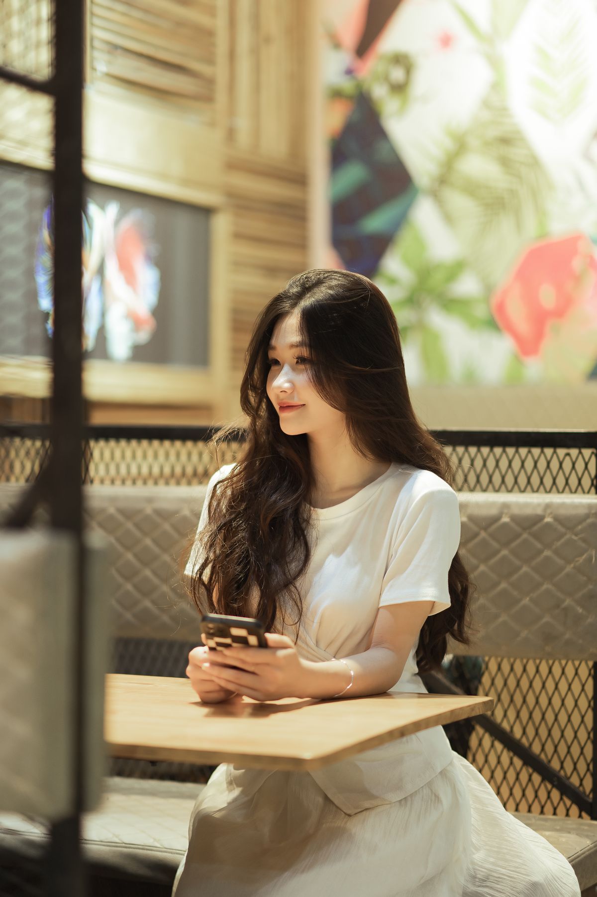 Woman smiling with a smartphone in a café