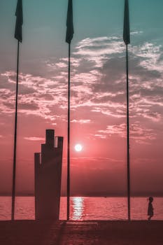 日落时分，一个孩子走在海滩上，天空充满活力，场景宁静