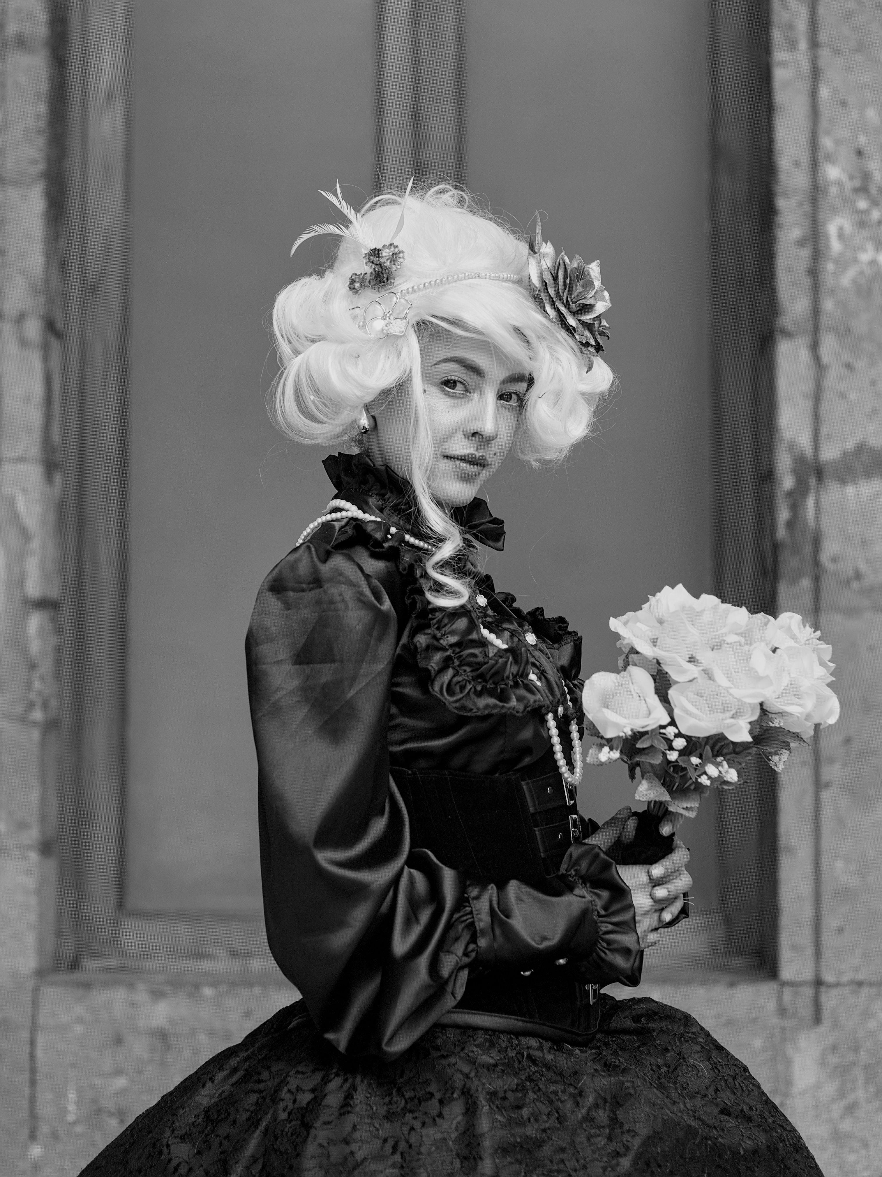 A woman in a black and white dress holding flowers · Free Stock Photo