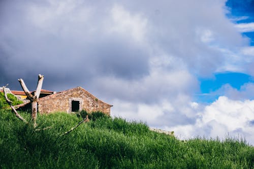 A small house on top of a grassy hill