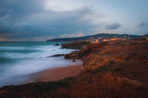 A cloudy sky with a beach and a rocky shore