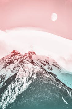 淡淡的天空下，白雪覆盖的山脉一片宁静，月亮依稀可见