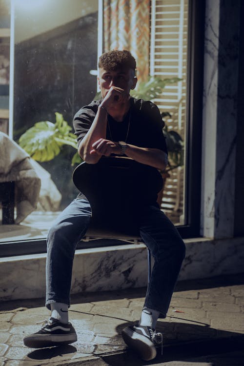 A man sitting on a chair with his phone