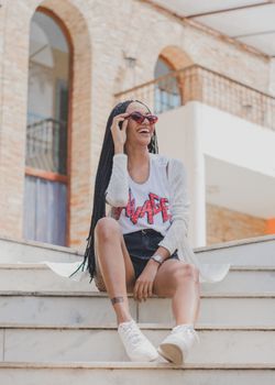 一位时尚前卫的女人戴着太阳眼镜，在户外享受阳光明媚的一天