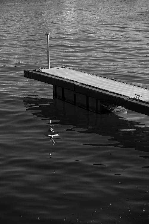 A black and white photo of a dock in the water