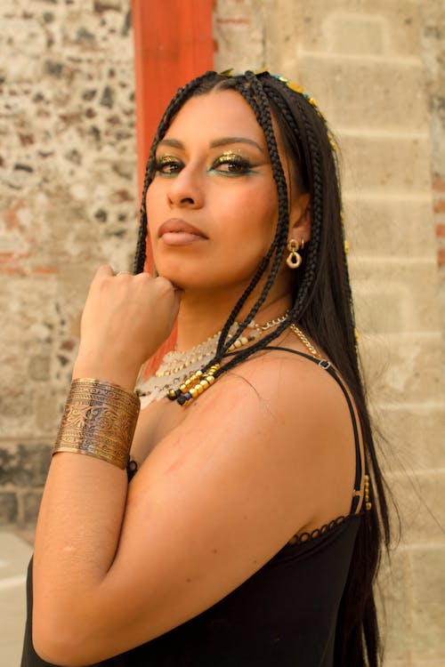 A woman with long hair and gold jewelry posing for a picture