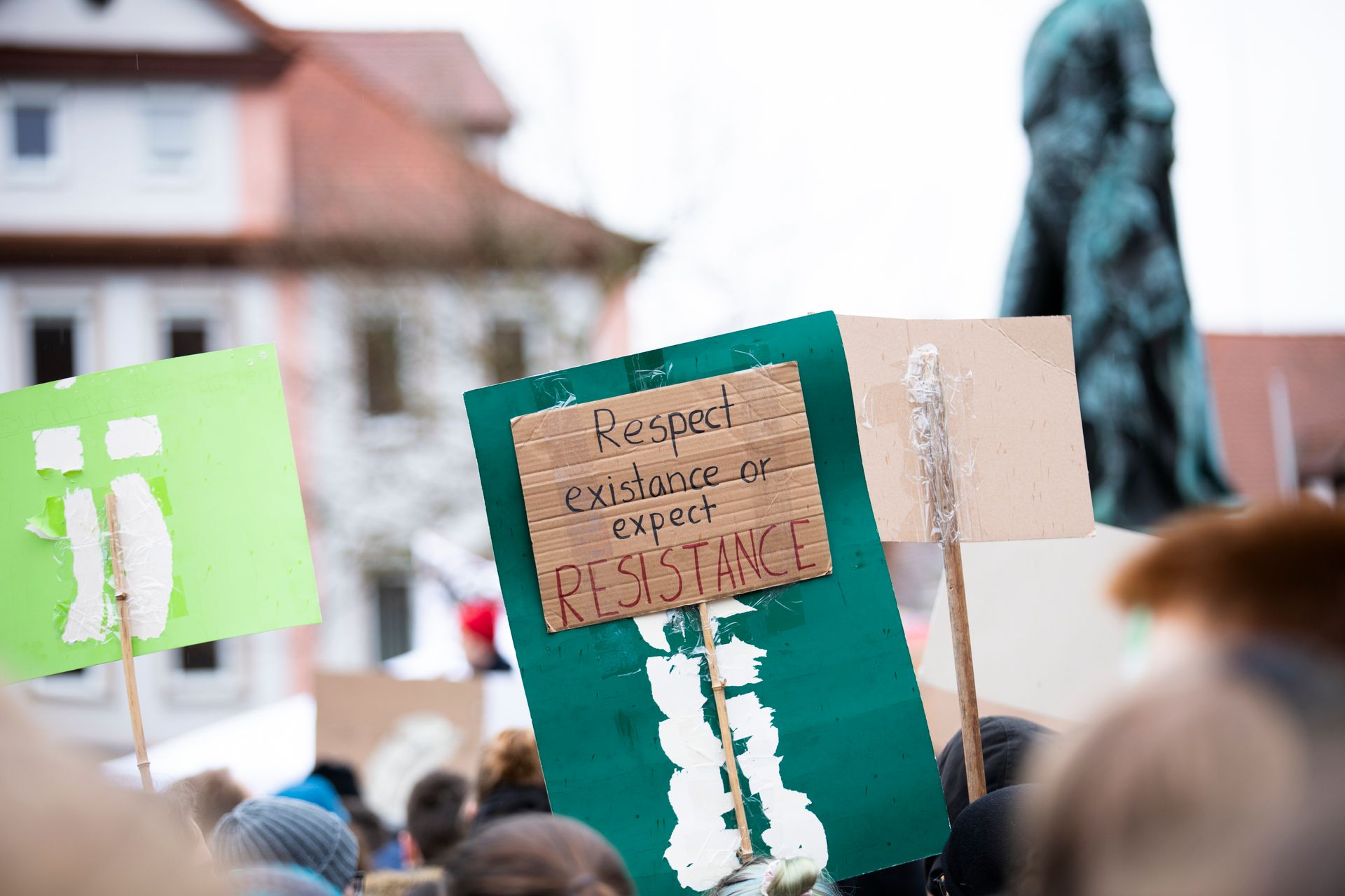 Person Holding Green and Brown Wooden Signage