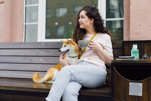 A woman sitting on a bench with a dog
