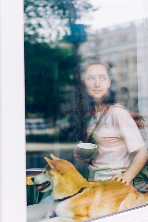 A woman is looking out the window of a cafe