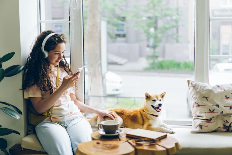 A Woman Wearing Headphones At Home 