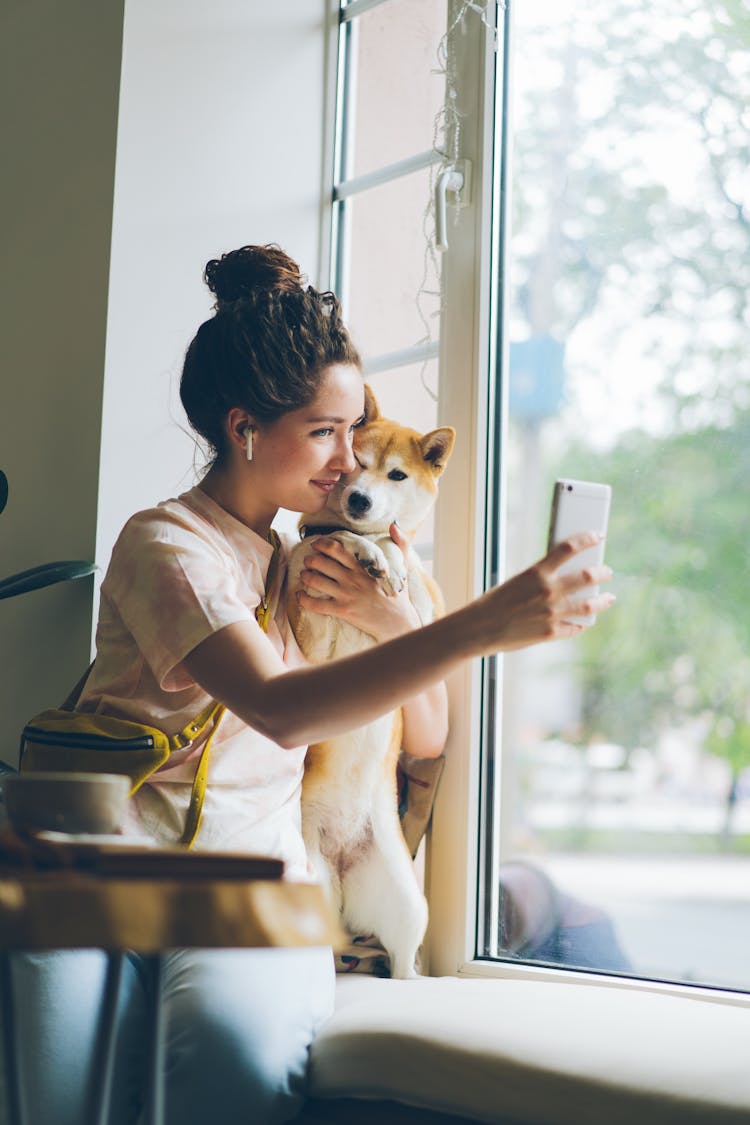 A Woman Taking A Selfie With A Dog