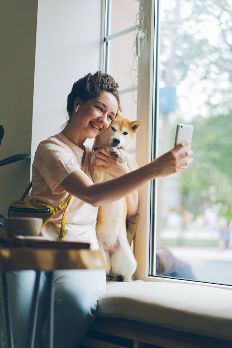 A Woman Taking A Selfie With A Dog