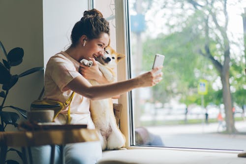 A woman taking a selfie with her dog