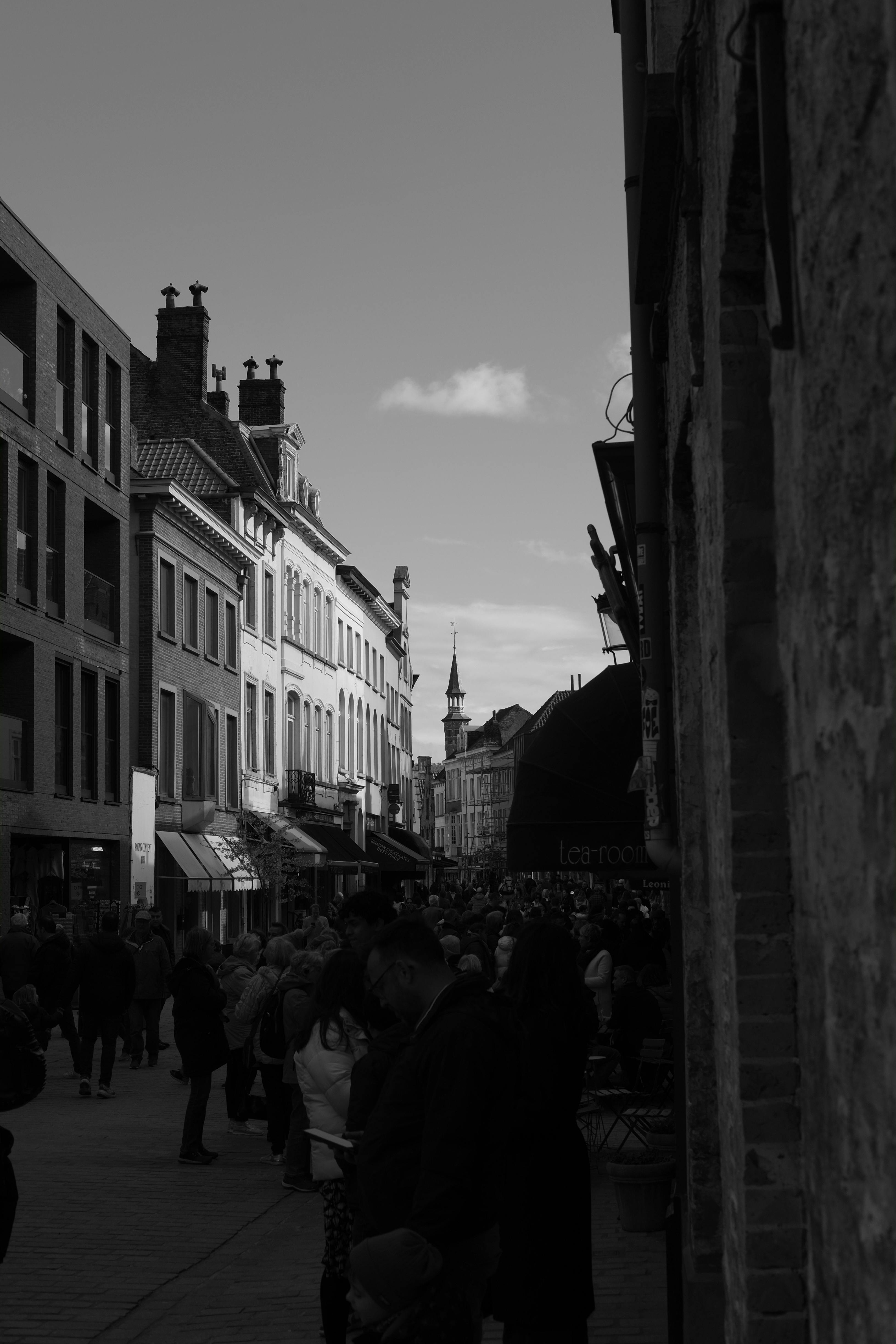 Black And White Photo Of A Crowded Street Between Buildings In A City black-and-white-photo-of-a-crowded-street-between-buildings-in-a-city
