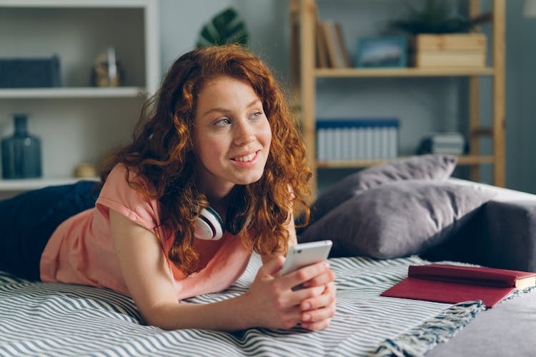 A Woman Lying With A Smartphone