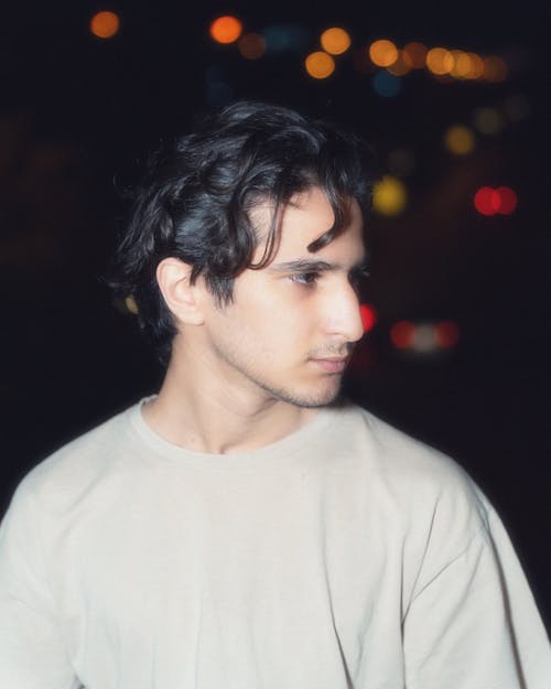 A young man with long hair and a white shirt