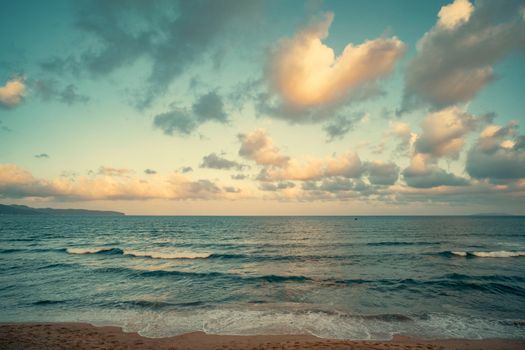 Peaceful seascape with calm waves and a vibrant sunset sky, perfect for tranquil settings.