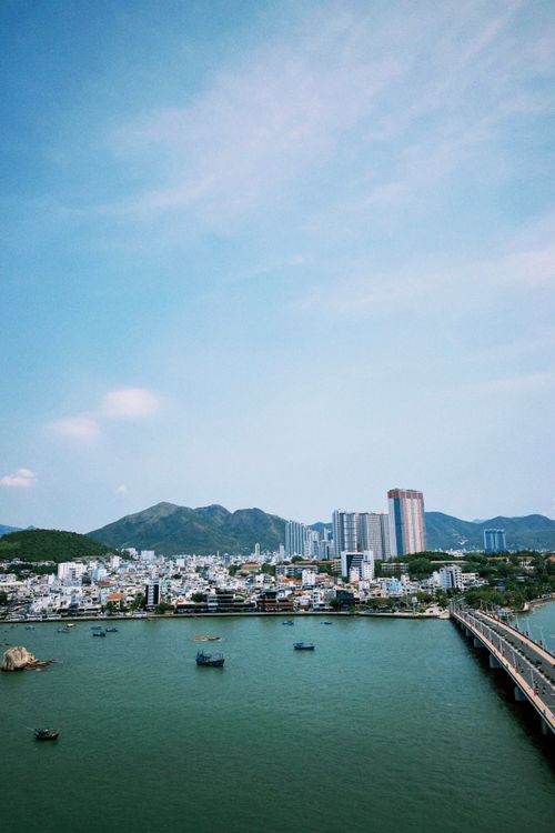 Free Aerial cityscape of Nha Trang, Vietnam with waterfront and mountains during the day. Stock Photo