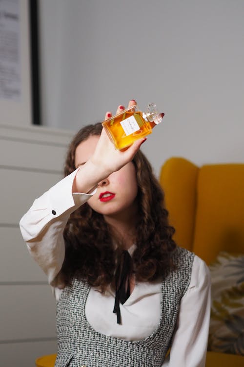 A woman holding up a bottle of perfume