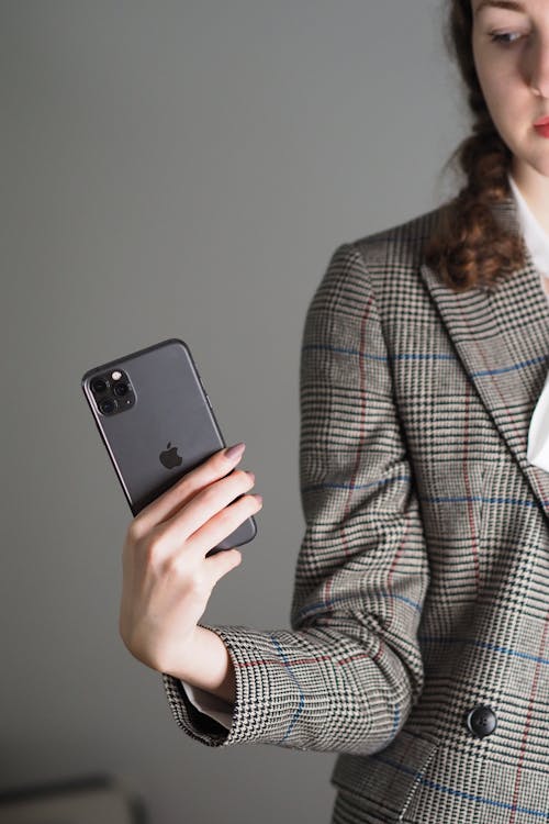 A woman in a suit holding an iphone