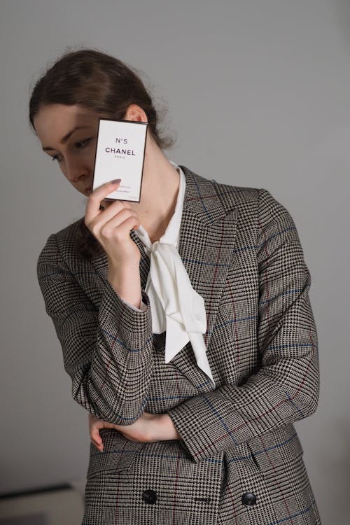 A woman in a suit holding a card