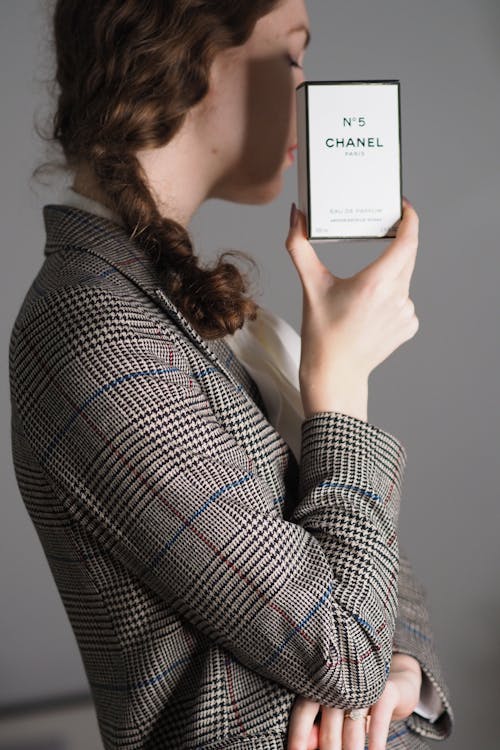 A woman holding up a phone with the words chanel on it