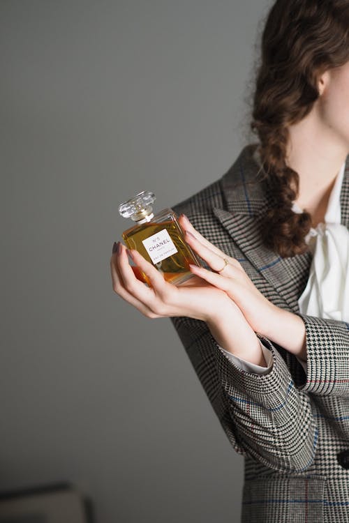 A woman holding a bottle of perfume