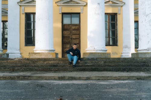 A man sitting on the steps of a building