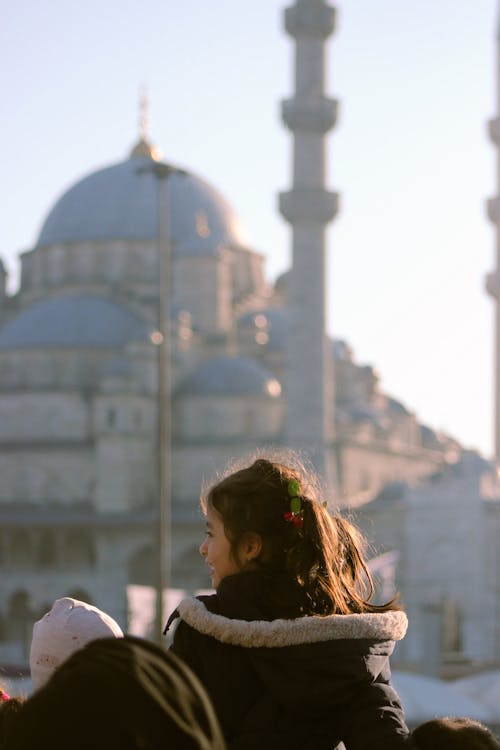 A young girl is looking at the blue mosque