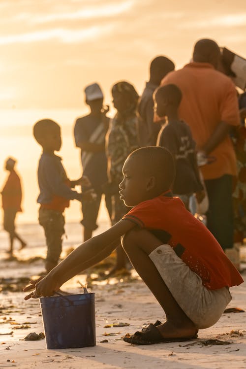 çocuk, çömelme, deniz kenarı içeren Ücretsiz stok fotoğraf