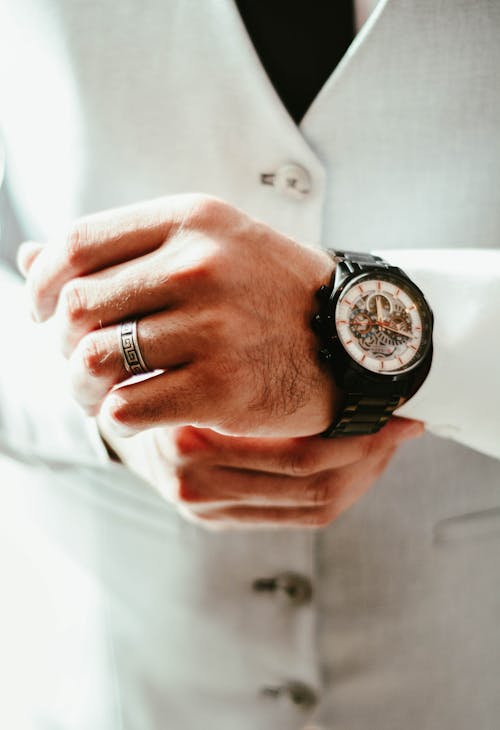 A man in a suit and tie is wearing a watch